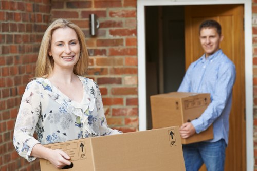 Local movers carrying furniture through a residential building in West Hampstead